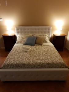 ein großes weißes Bett mit zwei Leuchten auf beiden Seiten in der Unterkunft La Casa di Manu Ortigia in Syrakus