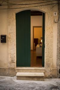 einen Eingang zu einem Gebäude mit grüner Tür in der Unterkunft La Casa di Manu Ortigia in Syrakus