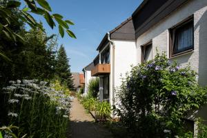 a garden with purple flowers next to a house at Gästehaus Tannenhof in Bad Bergzabern