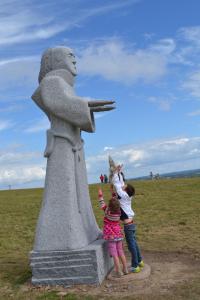 a group of children standing next to a statue at IDAVRO in Saint-Nicolas-du-Pélem