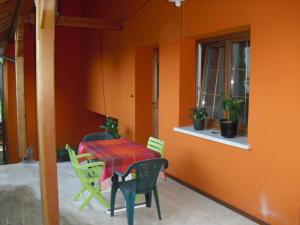 einen Tisch und Stühle in einem Zimmer mit orangefarbener Wand in der Unterkunft Gite S'Hiesla in Rammersmatt