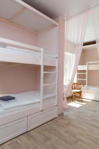 a bedroom with two bunk beds and a window at Botanika Hostel in Kazan