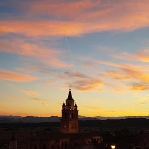 a clock tower in front of a sunset at Apartamento CabezoDoce in Calahorra
