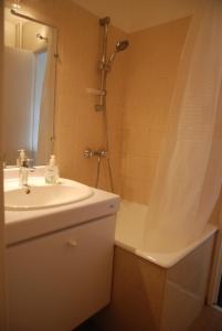 a bathroom with a sink and a shower and a tub at Appartements Paris Boulogne in Boulogne-Billancourt