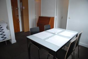 einen Konferenzraum mit einem weißen Tisch und Stühlen in der Unterkunft Appartements Paris Boulogne in Boulogne-Billancourt