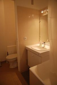a bathroom with a sink and a toilet and a mirror at Appartements Paris Boulogne in Boulogne-Billancourt