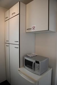 a microwave sitting on a shelf in a kitchen at Appartements Paris Boulogne in Boulogne-Billancourt