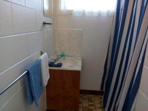 a bathroom with a sink and a blue shower curtain at Anchor In Holiday Units South Mission Beach in South Mission Beach