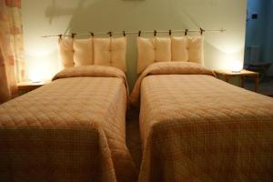 dos camas sentadas una al lado de la otra en una habitación en B&B La Braida, en Vinovo