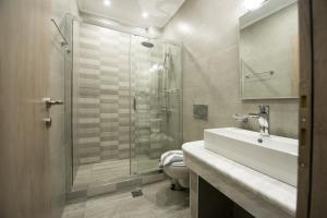ein Bad mit einer Dusche, einem Waschbecken und einem WC in der Unterkunft Tresor Apartments in Parga