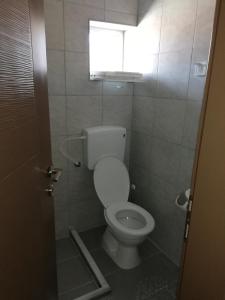 a bathroom with a toilet and a window at DIONIS Rooms & Apartments in Prilep