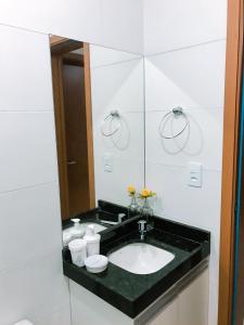 uma casa de banho com um lavatório e um espelho em APARTAMENTO JOÃO PESSOA BESSA em João Pessoa