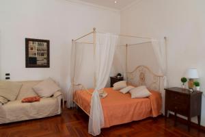 a bedroom with a canopy bed and a couch at Sistina 138 Luxury Home in Rome