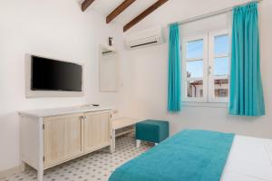 a bedroom with a bed and a desk with a tv at Monza House Otel in Siğacık