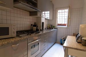 a kitchen with a stove and a microwave at Sistina 138 Luxury Home in Rome