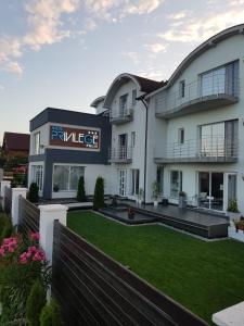 a large white building with a lawn in front of it at Vila Privilege Felix in Baile Felix