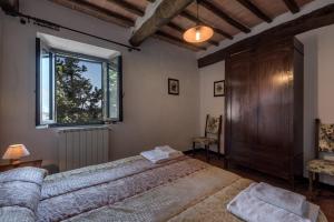 a bedroom with a large bed and a window at Agriturismo Tenuta Di Mensanello in Colle di Val d'Elsa