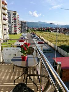 a balcony with a table with flowers on it at Luxury Mountain View Apartment in Braşov