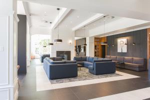 a lobby with blue couches and chairs in a building at Hotel Chateau Laurier Québec in Quebec City