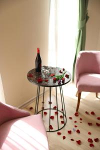 a table with a bottle of wine and flowers on the floor at Samsun Osmanlı Otel in Samsun
