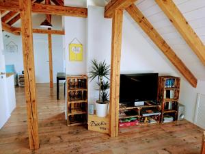 een woonkamer met een flatscreen-tv en houten balken bij Weinblick in Besigheim