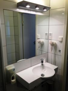 y baño con lavabo y espejo. en Torget Hotell, en Måløy