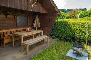 eine Terrasse mit einem Tisch, einer Bank und einem Sonnenschirm in der Unterkunft Ferienwohnungen Mildenberger in Birkenau