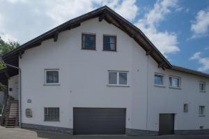 ein weißes Haus mit Garage in der Unterkunft Ferienwohnungen Mildenberger in Birkenau