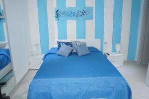 a blue bedroom with a bed with blue sheets and pillows at affittacamere BABY in La Spezia