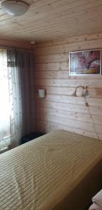 een slaapkamer met een bed met een houten muur bij Tilhi 1 Cottage in Piojärvi