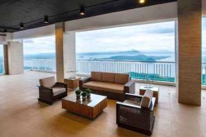 a living room with a couch and chairs and a large window at Wind Residence T4- M Near Taal view at Skylounge in Tagaytay