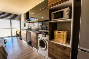 a kitchen with a washing machine and a microwave at Hotel Standard Stylish Studio - contactless check-in&check out in Famagusta