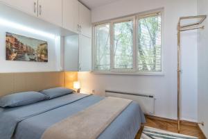 a bedroom with a bed and two windows at Apartment DOLCE CASA in Varna City