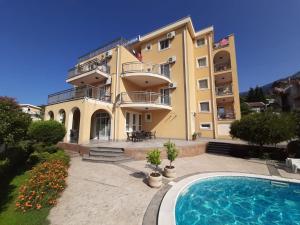 a large building with a swimming pool in front of it at Villa Laguna in Sutomore