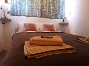 a bed with a blanket and a towel on it at Apartman Korzo in Varaždin