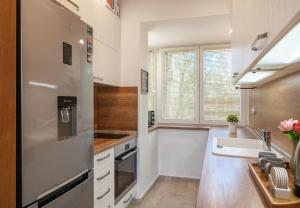 een keuken met een roestvrijstalen koelkast en een wastafel bij Apartment DOLCE CASA in Varna