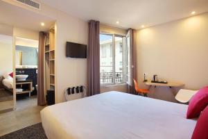 Una habitación de hotel con una gran cama blanca y una ventana. en Hotel Auguste, en París