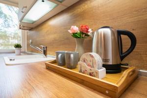 a kitchen counter with a tray with a tea kettle and mugs at Apartment DOLCE CASA in Varna City