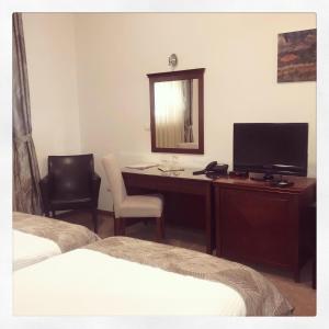 a bedroom with a desk with a television and a mirror at Garni Hotel Semlin B&B in Belgrade