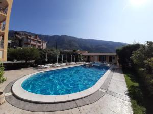 a large swimming pool with chairs and a building at Villa Laguna in Sutomore