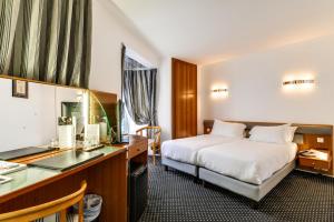 a hotel room with a bed and a desk at Villa Luxembourg in Paris