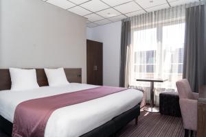 Een bed of bedden in een kamer bij Hotel Luxer