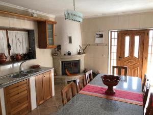 a kitchen with a dining table and a fireplace at Casa da Quinta da Prelada Simão in Celorico de Basto
