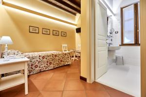 a room with a bed and a table and a door at Albergo Trattoria Il Leone in Pomponesco