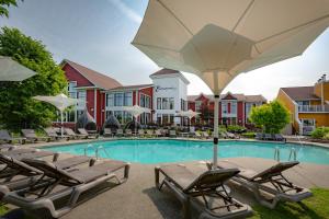 a pool with chairs and an umbrella in front of a hotel at Estrimont in Magog-Orford
