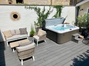 a hot tub on a patio with a couch and chairs at La Maison Odeia Bordeaux Centre in Bordeaux