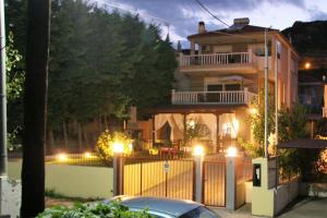 a house with a gate and a fence with lights at Fotis Resort in Iraklitsa