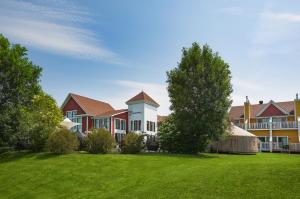 a large house with a green lawn in front of it at Estrimont Suites & Spa in Magog-Orford