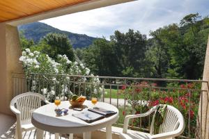 d'une table et de chaises sur un balcon avec vue. dans l'établissement Vacancéole - Le Domaine de Chames - Pont d'Arc, à Vallon-Pont-dʼArc