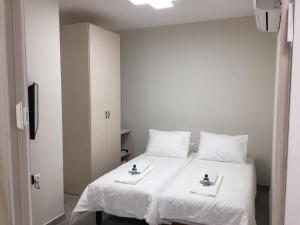 um quarto com uma cama branca e 2 almofadas brancas em Segal in Jerusalem Apartments em Jerusalém